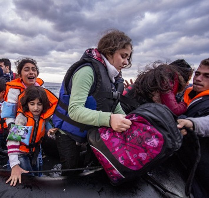 October 2015: Syrian refugees arrive from Turkey to Lesvos Island, Greece, by inflatable dinghy. (Photo by Nicolas Economou, Shutterstock.com)
